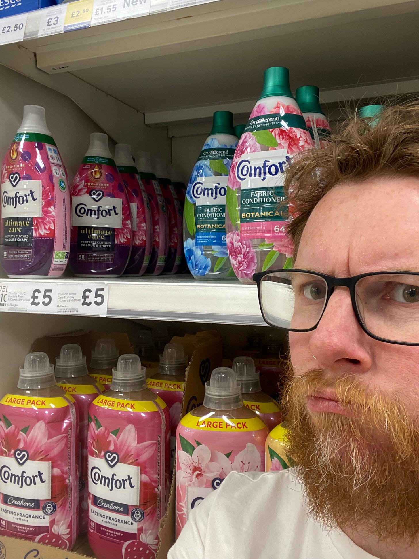 A bearded man in front of the Comfort-branded detergent in a supermarket. A bearded man in front of the Comfort-branded detergent in a supermarket.