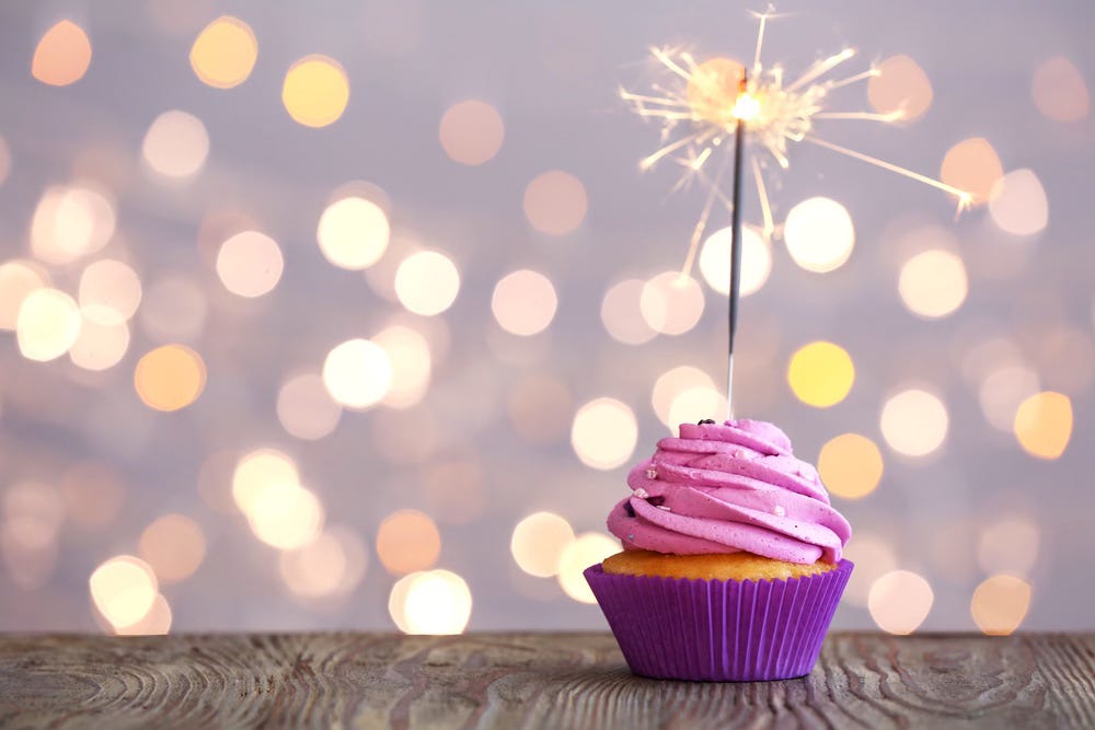 Birthday cupcake with twinkle lights in background