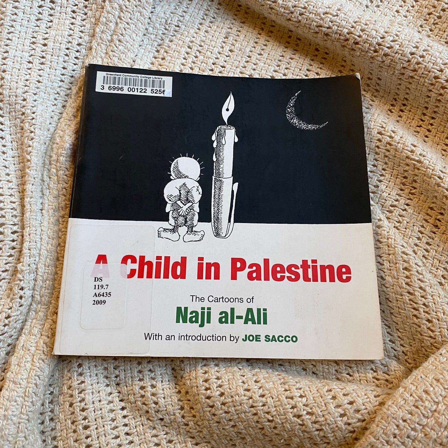 A Child in Palestine lies on a white blanket.