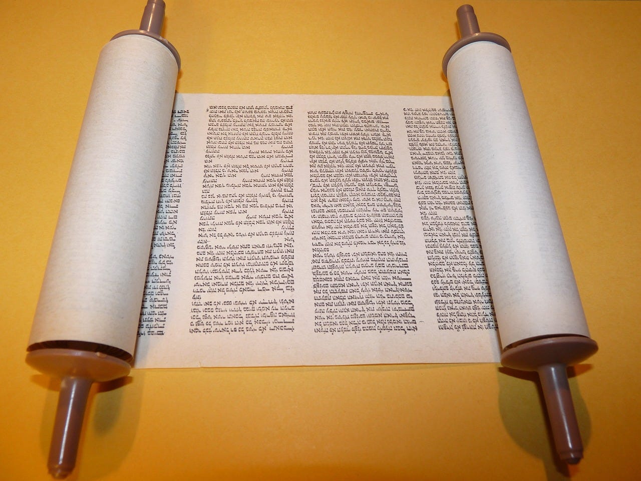 an open Torah scroll showing Hebrew writing