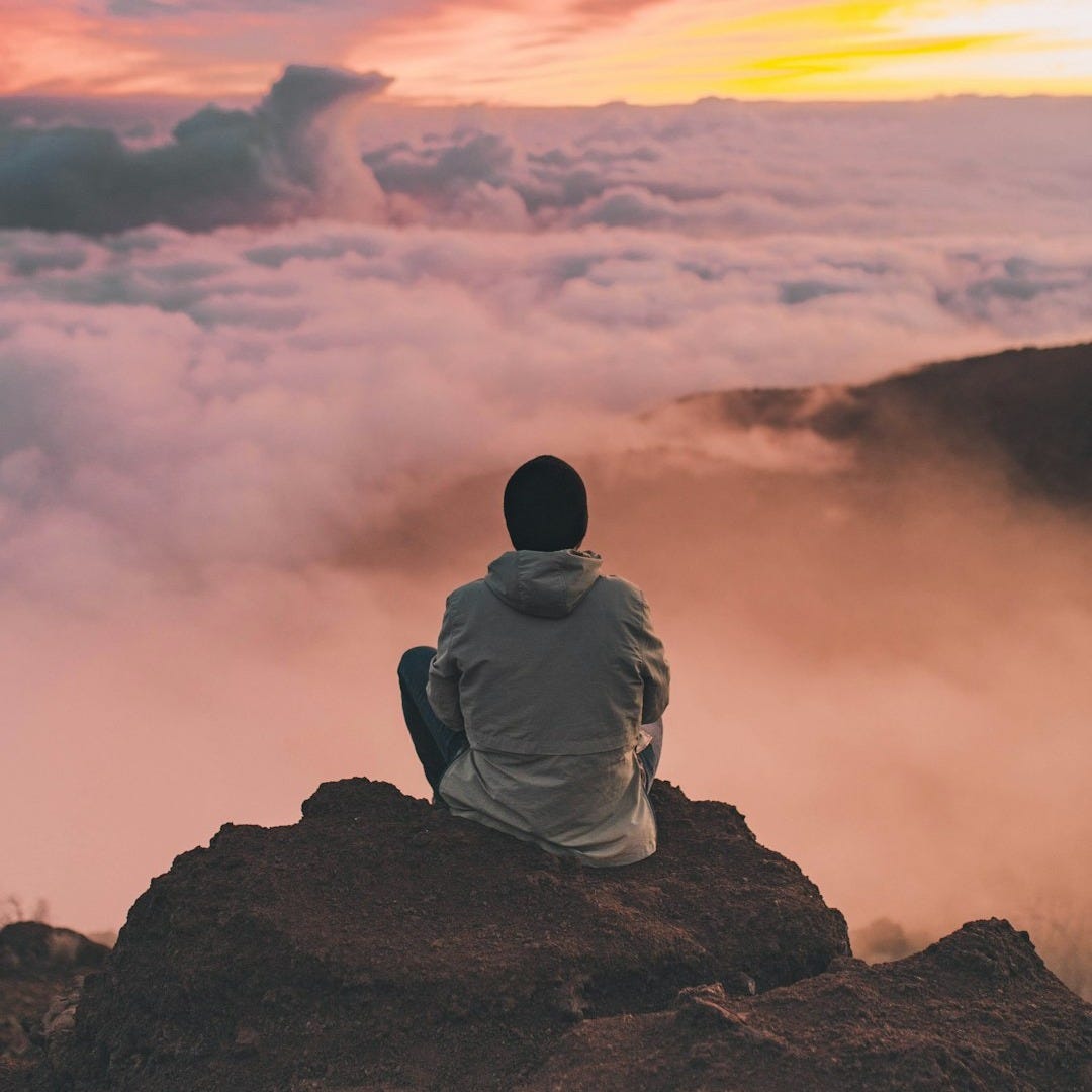 man sitting on cliff man sitting on cliff