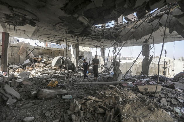 Two Palestinans boys walk through the rumble of a home in Rafah that was bombed by the Israeli Defense Force (IDF) that left no survivors on May 03, 2024. Photo by Ismael Abu Dayyah via AP.