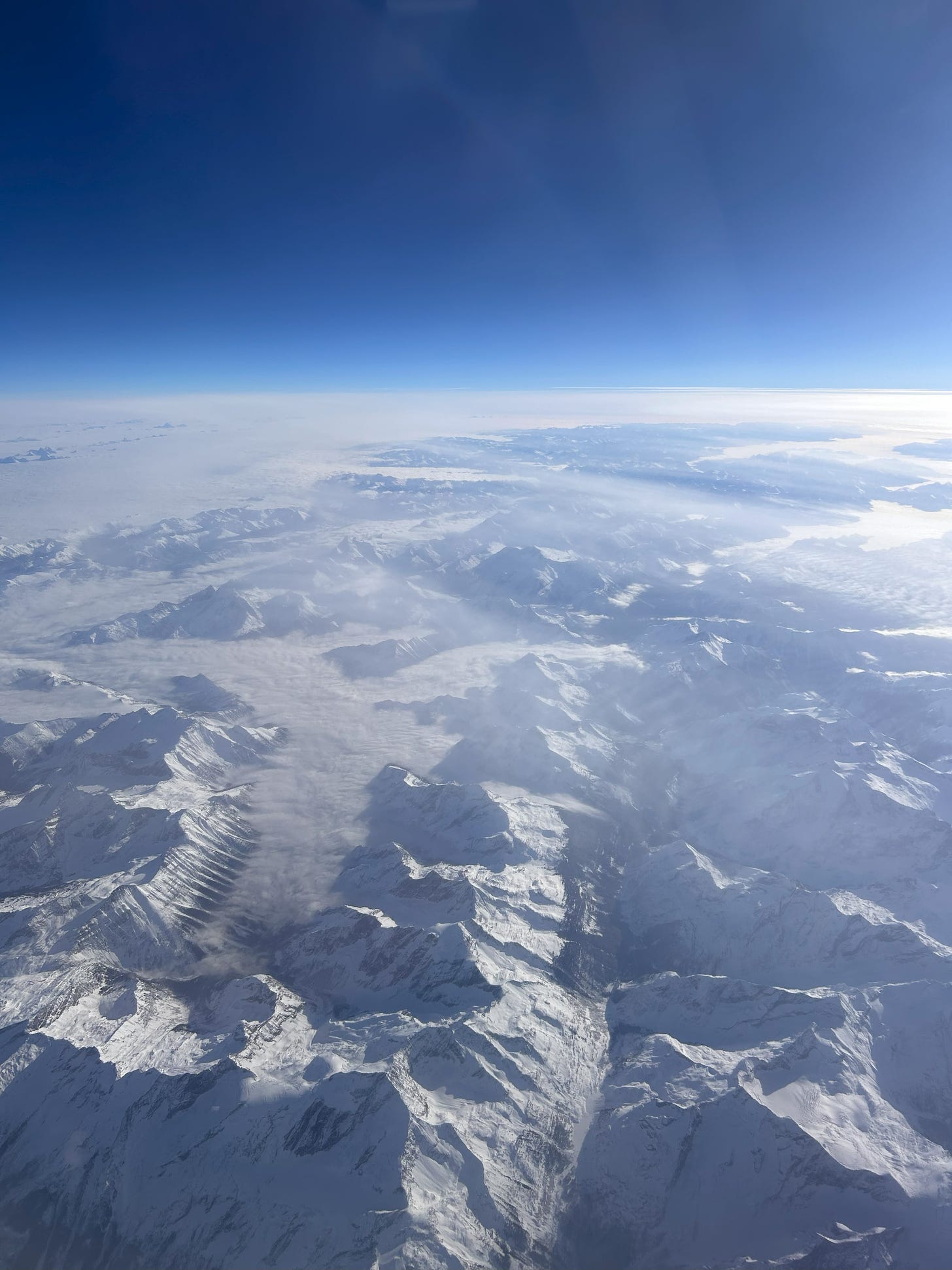 aerial view of snow-capped mountains against a blue sky