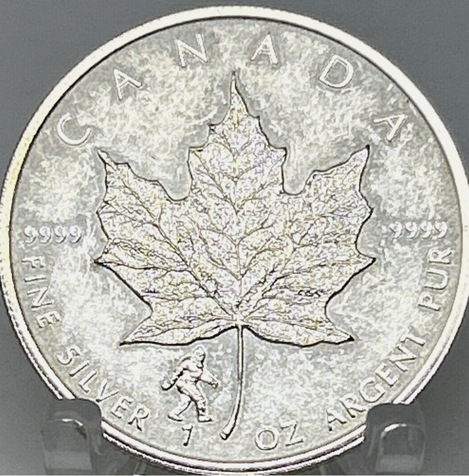 A silver coin with a maple leaf

Description automatically generated