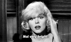 GIF: Marilyn Monroe taps on her own head and says, "Not very bright"