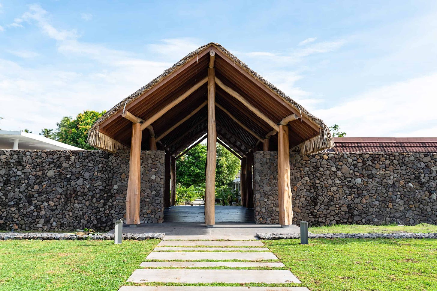 Photographie représentant une ouverture dans un mur, recouverte d'un toît, dans les nouveaux aménagement de Te Fare Iamanaha – Musée de Tahiti.