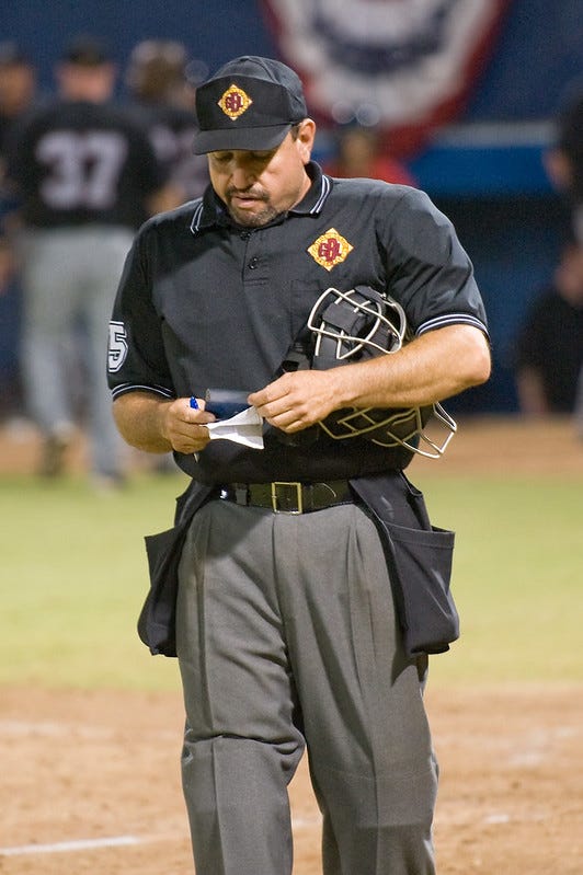 Umpire pretends to check his notes while regaining his composure
