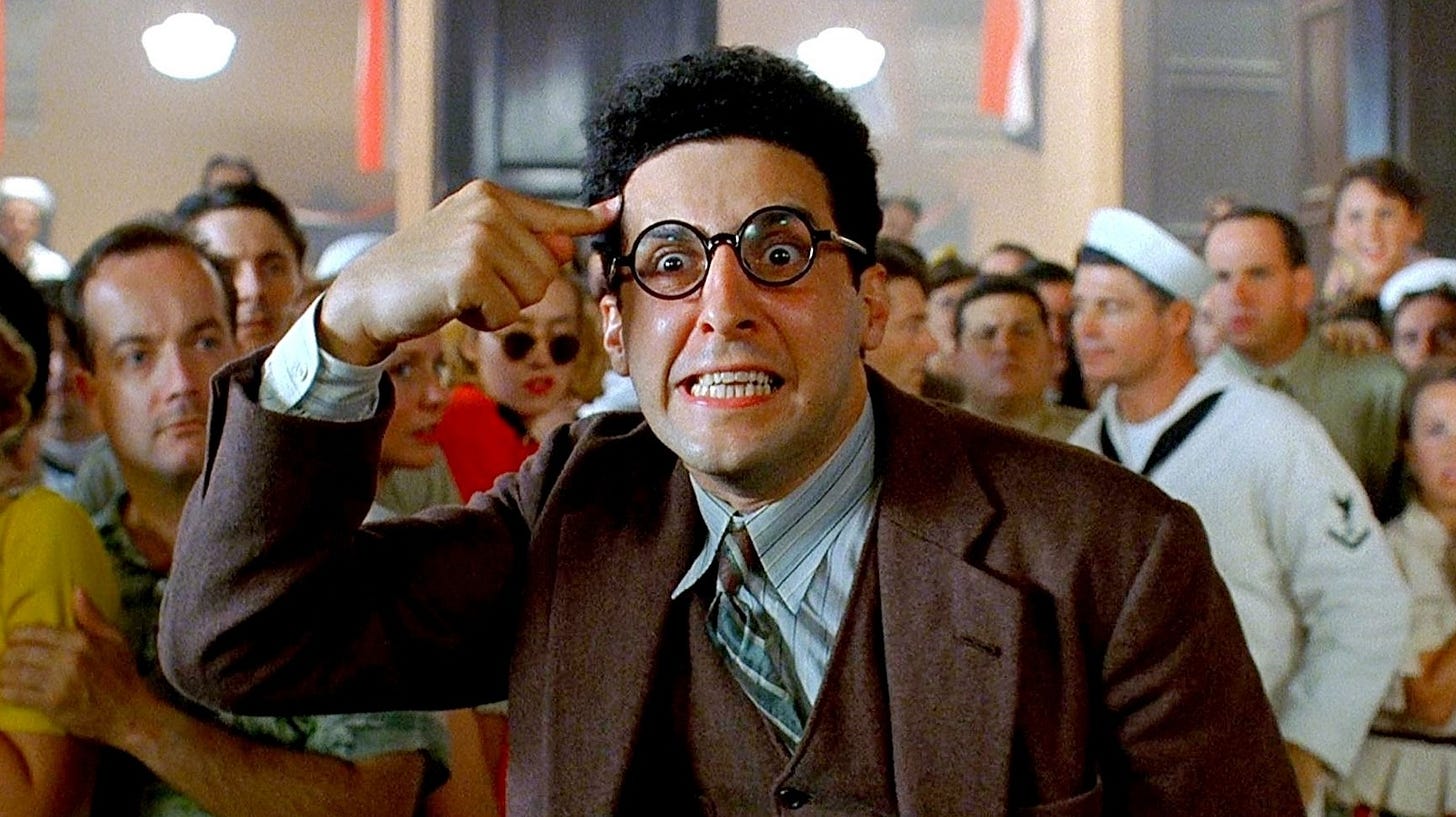 Screenshot from the film Barton Fink showing the title chracter with a crazed expression in front of a crowd of people.