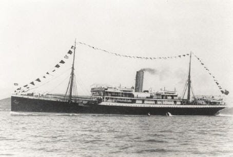 A black and white photo of SS Mendi, a modestly sized ship, bedecked in flags and without a care in the world.