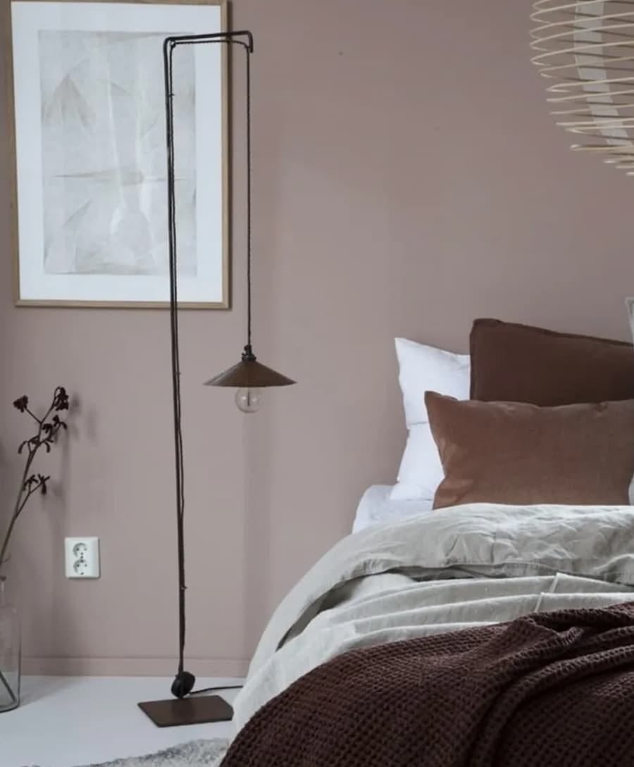 muted, warm neutral bedroom with cosy accessories on the bed