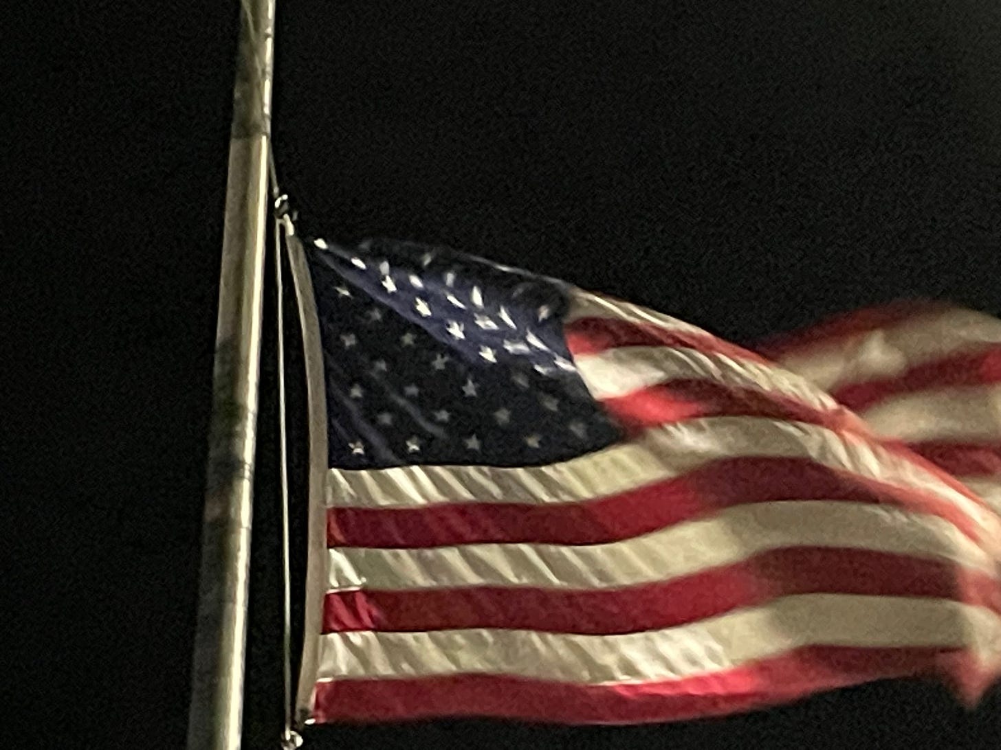 An American flag, flying at night.