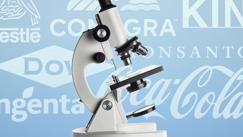 A cut-out image of a microscope in front of a light blue background with logos for companies including Nestle, Dow, and Coca-Cola