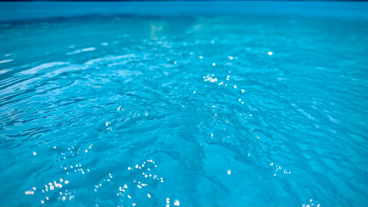 A very blue photograph of the inside of my paddling pool with water rippling.