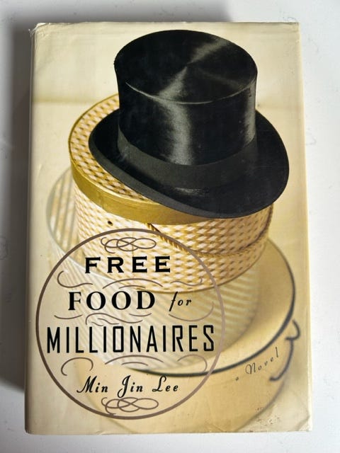 A top hat rests atop hat boxes on the cover of Free Food for Millionaires