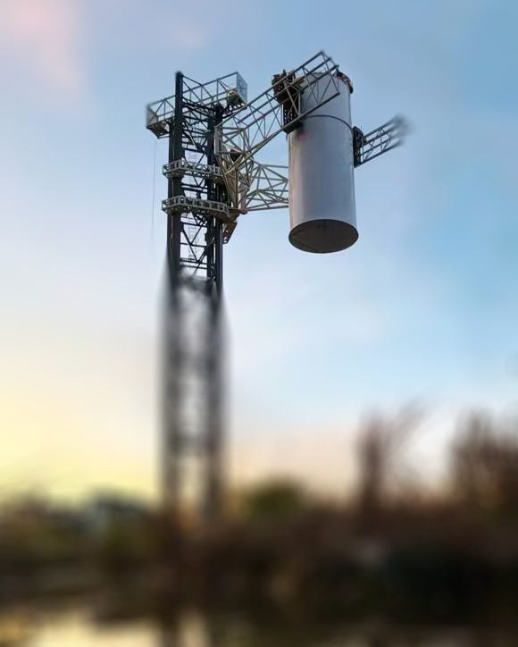 Cosmoleap’s catch tower lifting a pathfinder section of a first-stage booster.