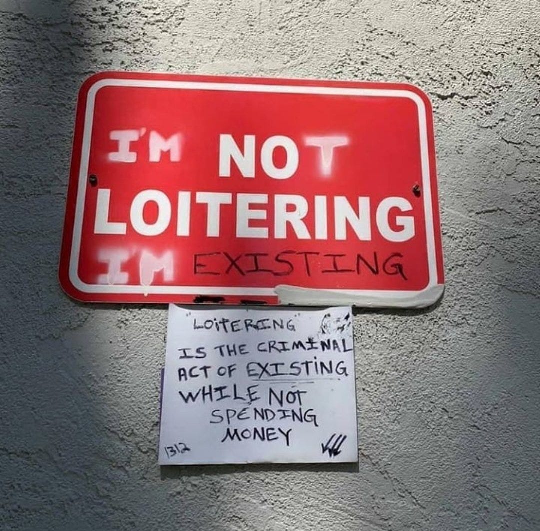 Red sign on wall, originally reading "No loitering" has been grafittid to read 'I'm not loitering i'm existing', and a handwritten note pasted beneath reads "loitering is the criminal act of existing while not spending money"