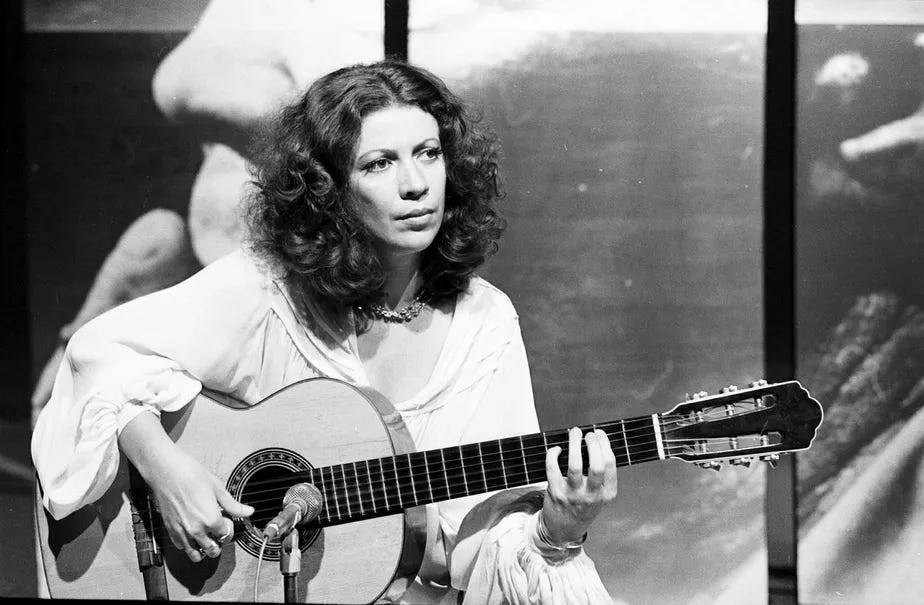 Foto em preto e branco de Beth Carvalho jovem tocando violão.