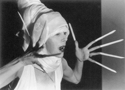 Black and white photo of a woman posing with extremely long fingernails