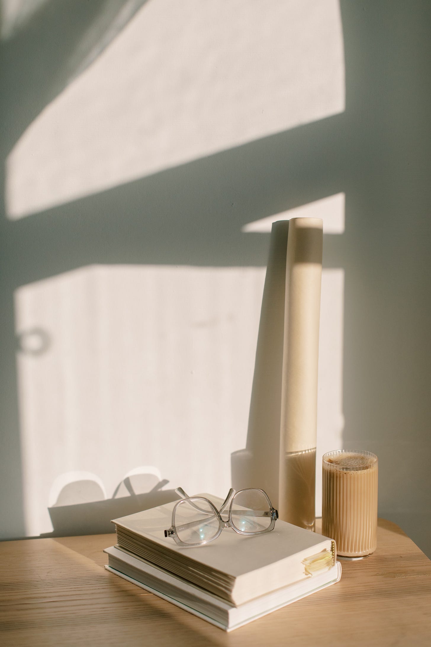 a pair of glasses sitting on top of a pile of books