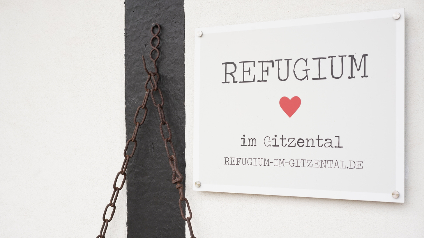 The sign outside my self imposed residency in Germany. It reads "Refugium" with a heart illustration underneath, followed by the words im Gitzental.