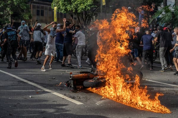 A motorcycle engulfed in flames on a street.