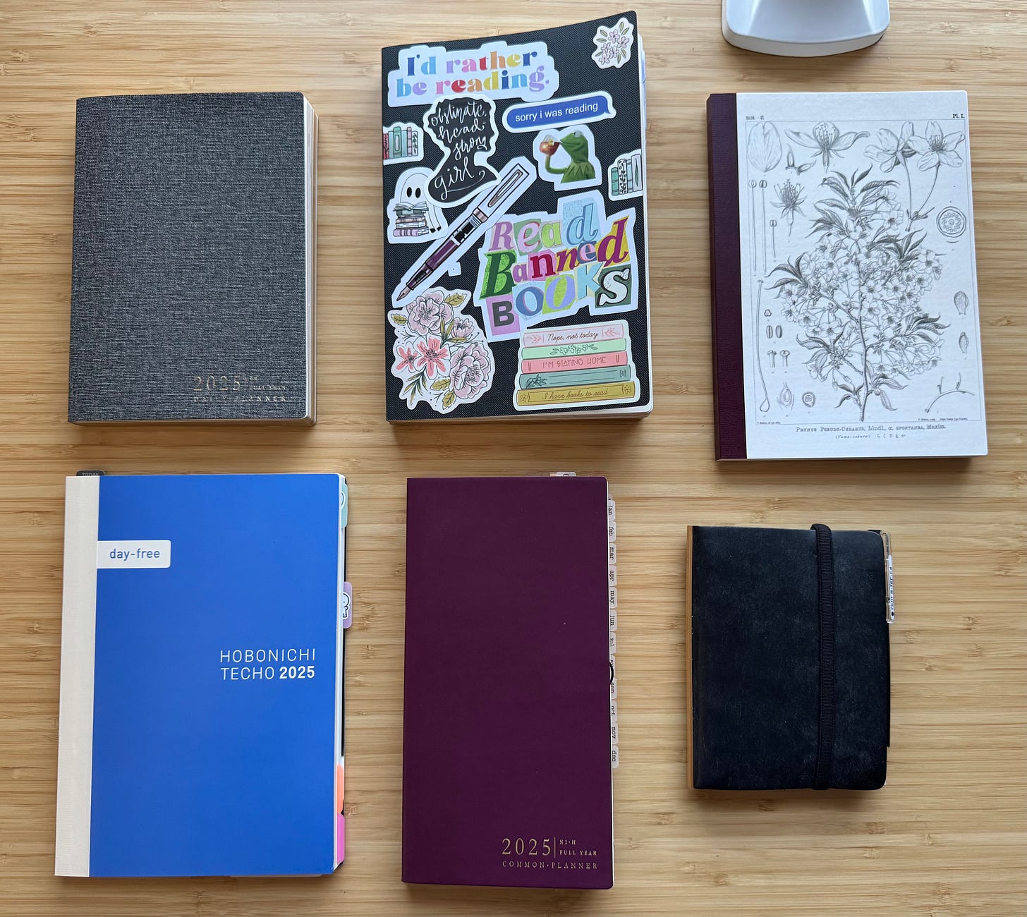Six notebooks and planners on a desk. See caption for details. Six notebooks and planners on a desk. See caption for details.