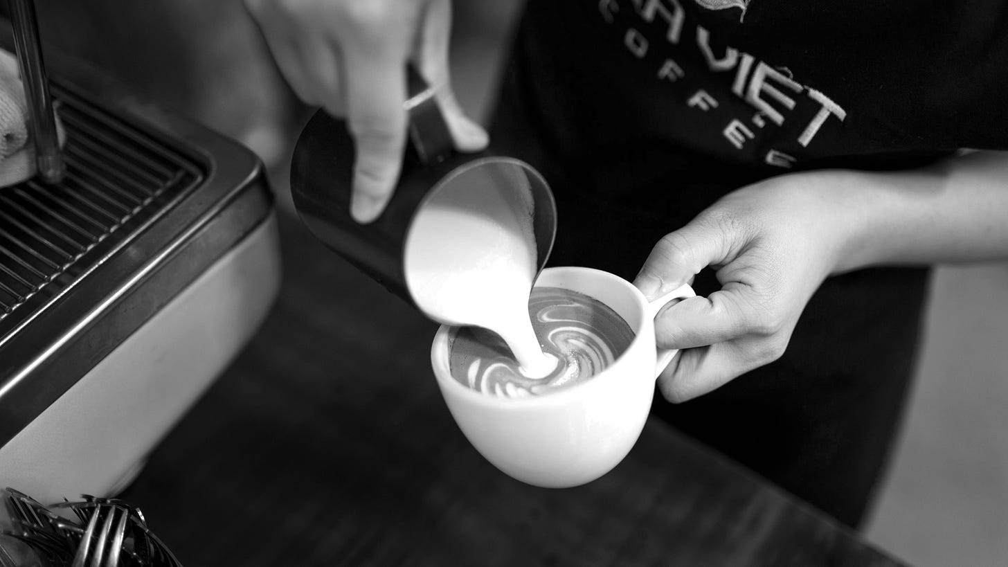 Close up of a barista pouring latte art