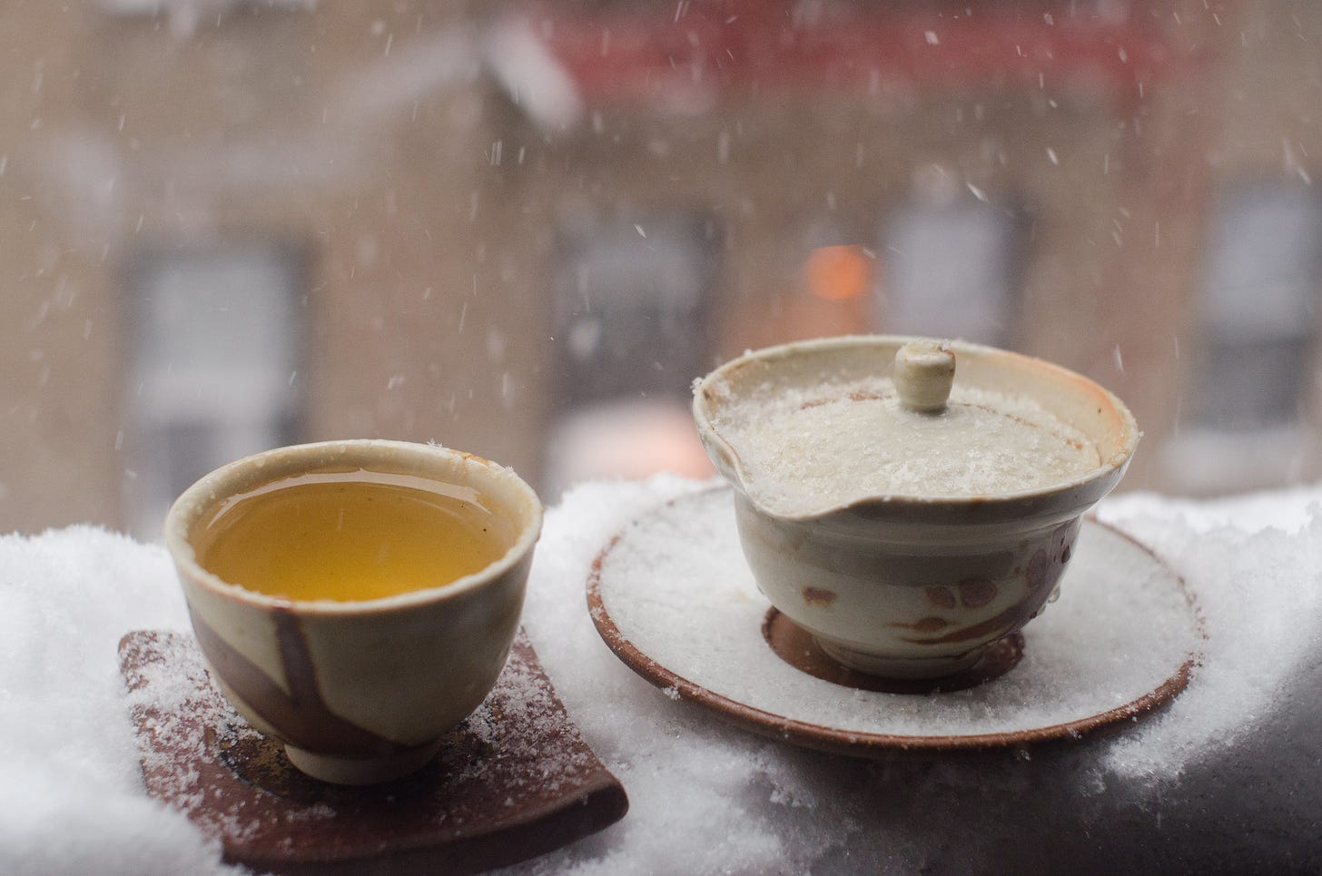 ID: Small teacup and pot on a snowy windowsill