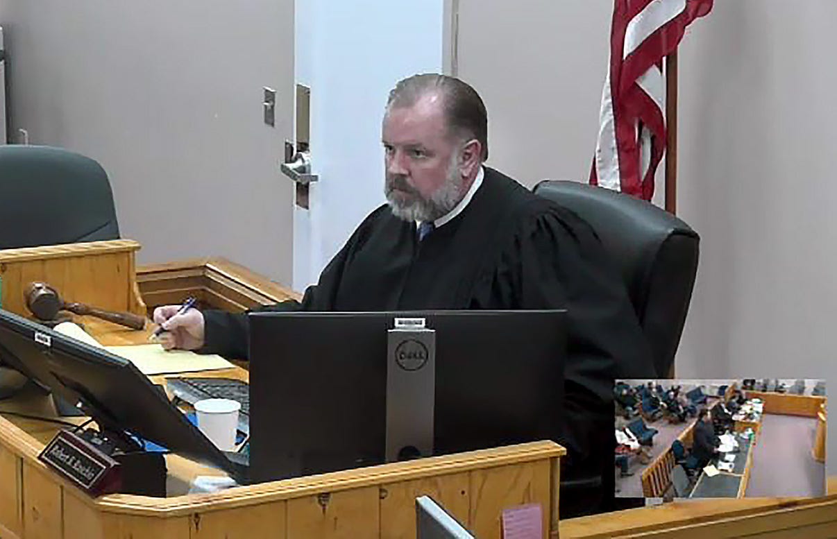 In this screenshot from a video feed, Harney County Circuit Court Judge Robert S. Raschio presides over arguments about Measure 114 during a hearing in Burns, Ore., on Dec. 13, 2022.