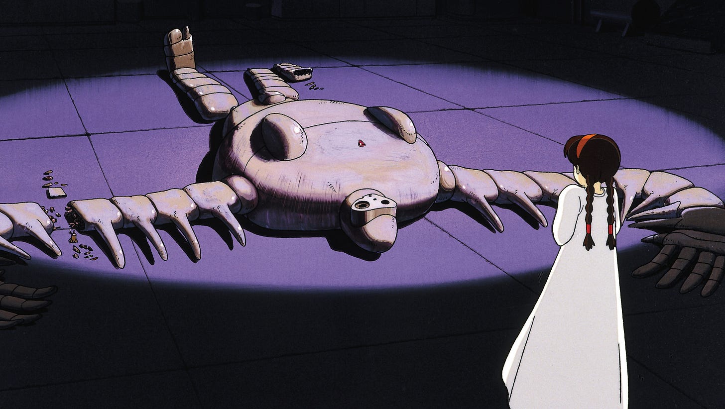 A scene from an animated movie featuring a young girl wearing a white dress looks at a huge, pale, broken robot in a pool of light on a stone floor.