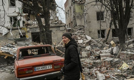 A woman stands in front of a destroyed building after a deadly strike in the city of Sloviansk yesterday.