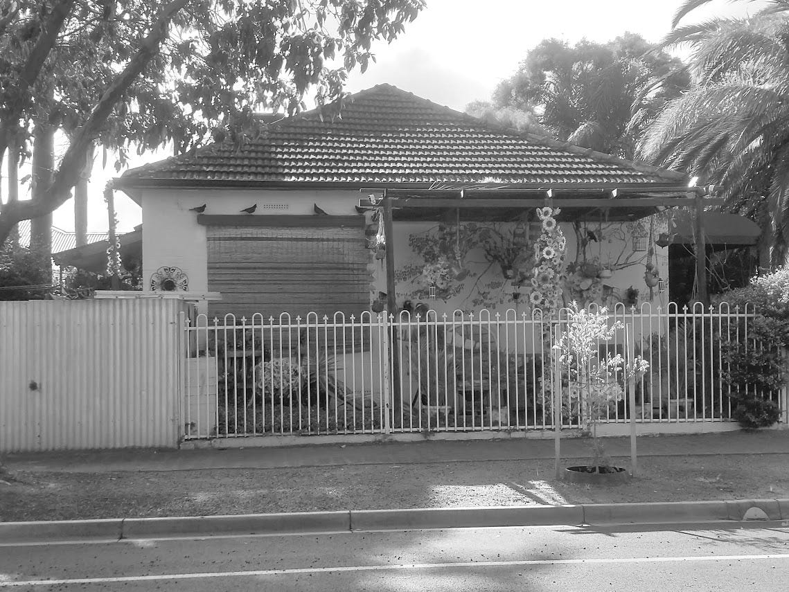 Fachada de una casa en Australia, rodeada de naturaleza y decoraciones