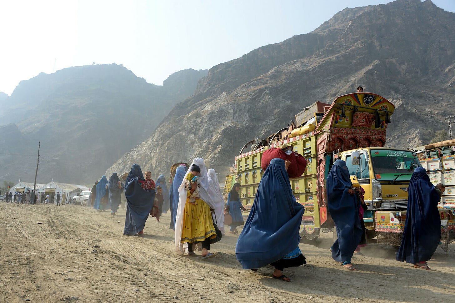 <p>Burqa-clad Afghan refugees arrive at the United Nations High Commissioner for Refugees (UNHCR) repatriation center in Torkham, as they cross through the main border between Afghanistan and Pakistan to return to their home country after fleeing civil war and Taliban rule. Photo: NOORULLAH SHIRZADA/AFP/Getty Images</p>