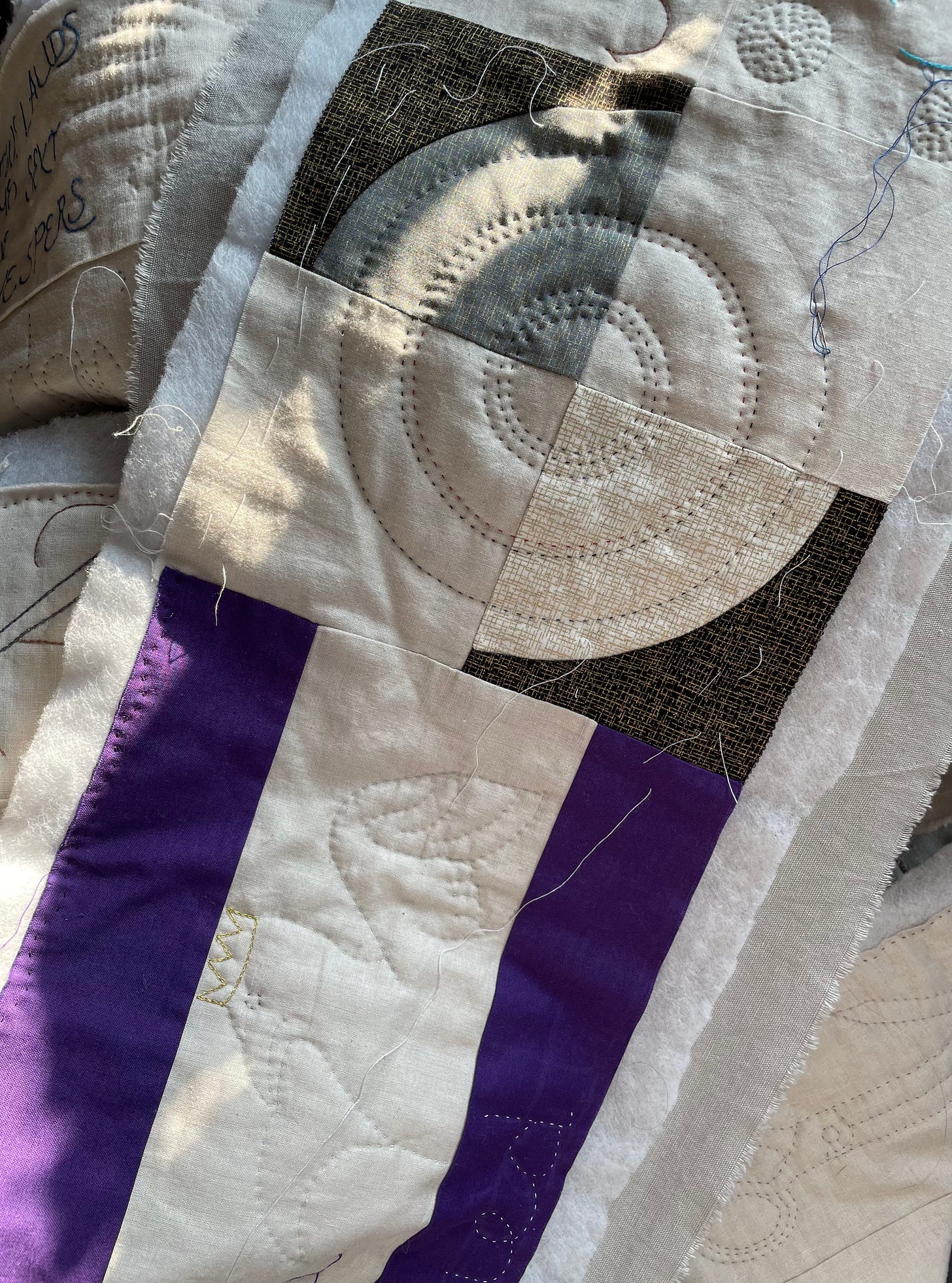 Quilting in progress - a drunkard’s path block which is a mirror image circular shape. Below the drunkard’s path is a quilted falcon wearing a crown.
