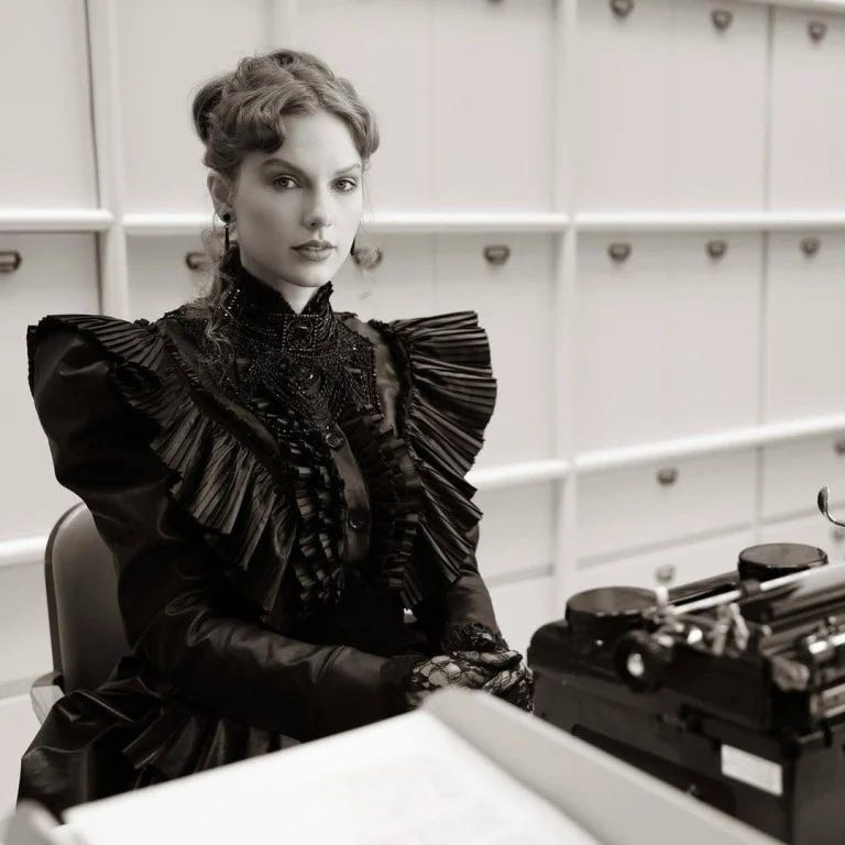 Taylor Swift in Victorian dress sitting in front of a type writer, photo in black and white