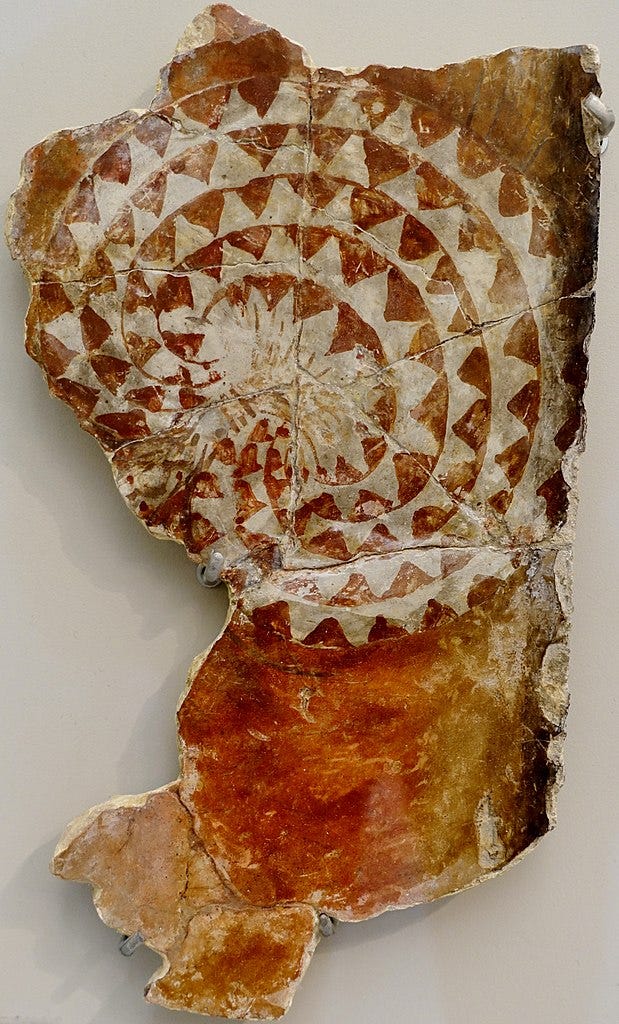 A heavily damaged ancient fresco showing a coiled-up snake with a red and white triangle scale pattern.