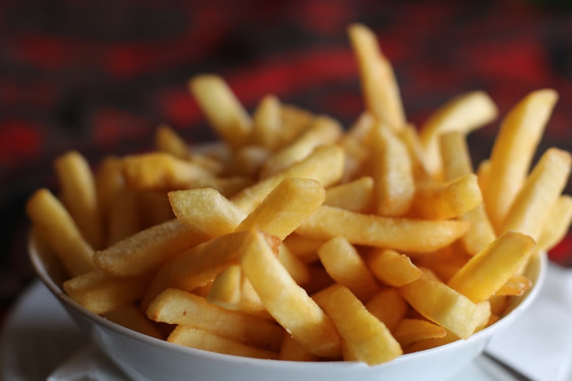 Free Delicious crispy golden french fries served in a white bowl, perfect for a tasty snack. Stock Photo