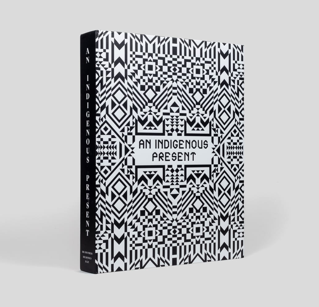 The book "An Indigenous Present" featuring a Native black and white pattern on the cover.