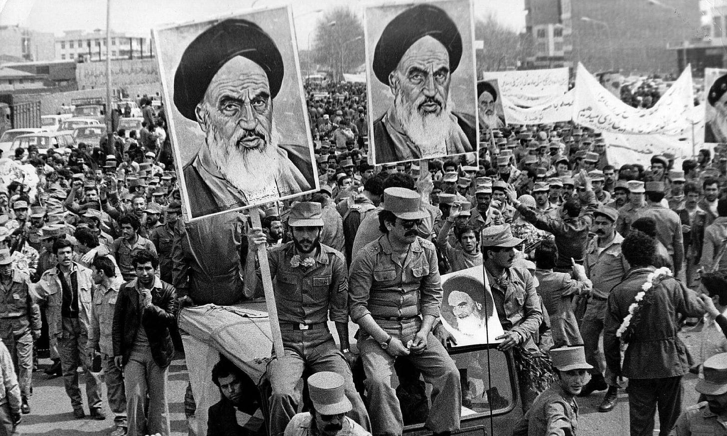 Iranian Islamic Republic Army soldiers carry posters of the Ayatollah Khomeini during the revolution of 1979.