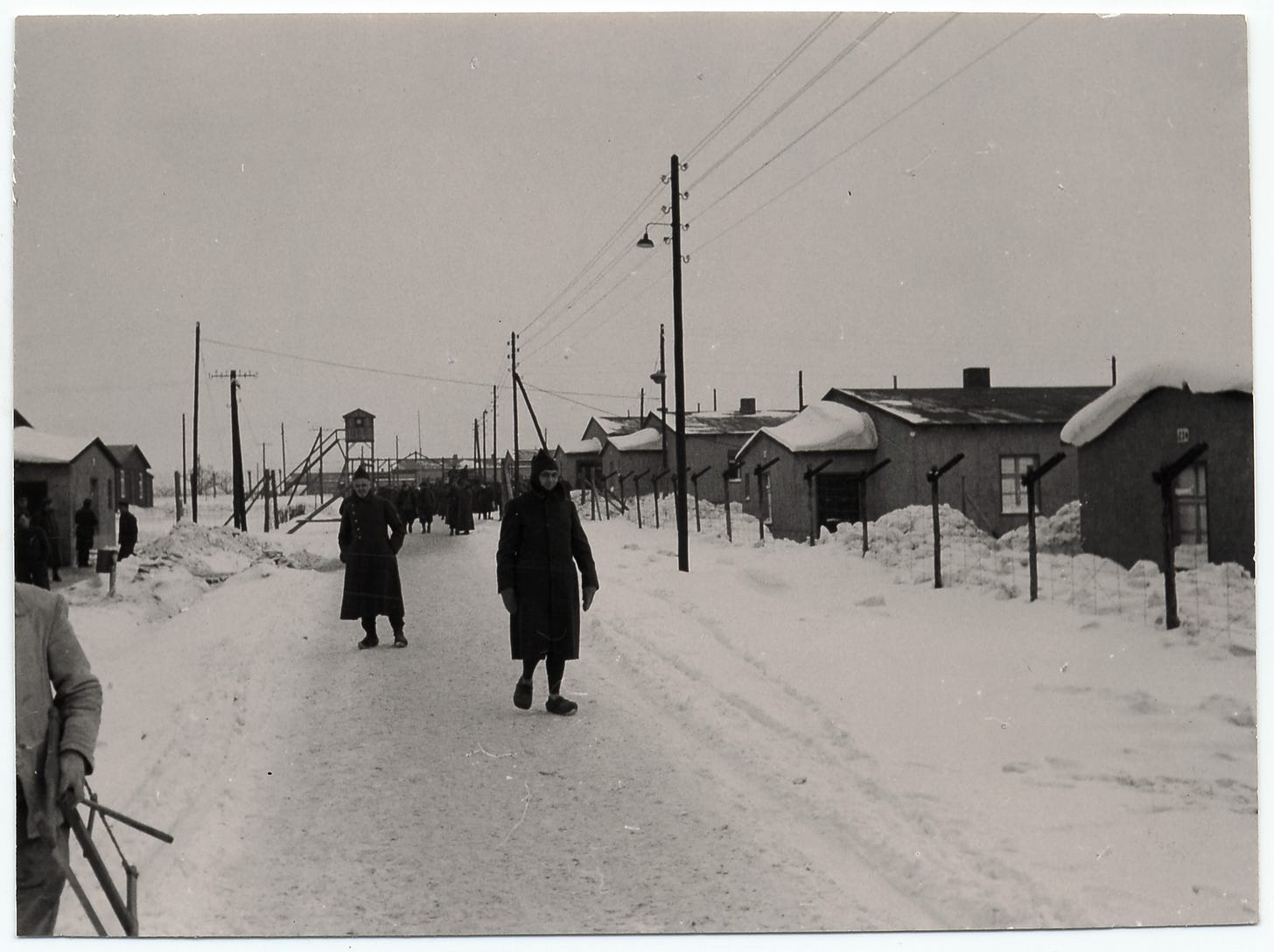 men walking in snowy terrain along a road