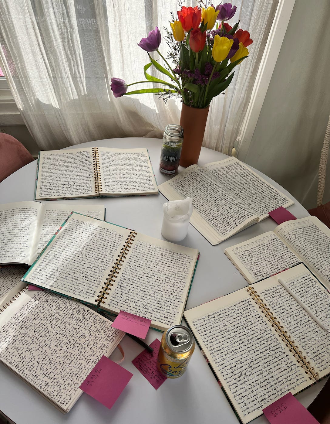 A table with a bunch of notebooks open.