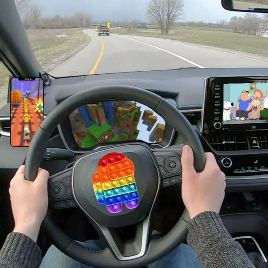 POV of someone driving with a phone on the right playing Subway Surfers and the gauges covered by Minecraft and Family Guy playing on the center console screen and a rainbow Among Us fidget popper on the steering wheel