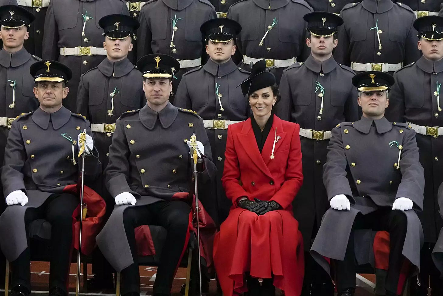 Prince and Princess of Wales seated with the Welsh Guard. All are wearing the Leek on their uniforms, which is a national symbol of Wales.