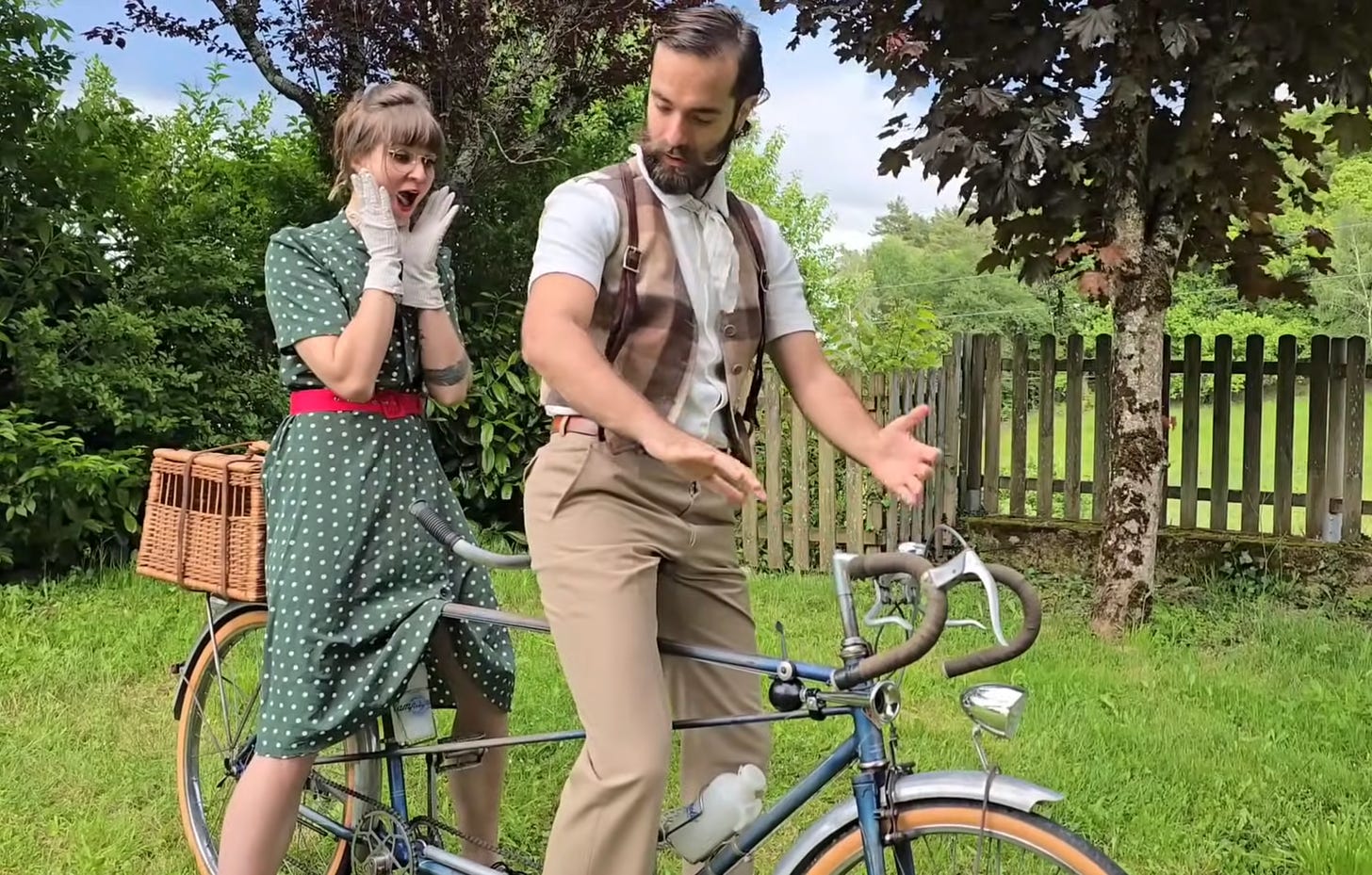 deux cyclistes habilles en tenue des annees 50 sur un velo tandem dans un jardin