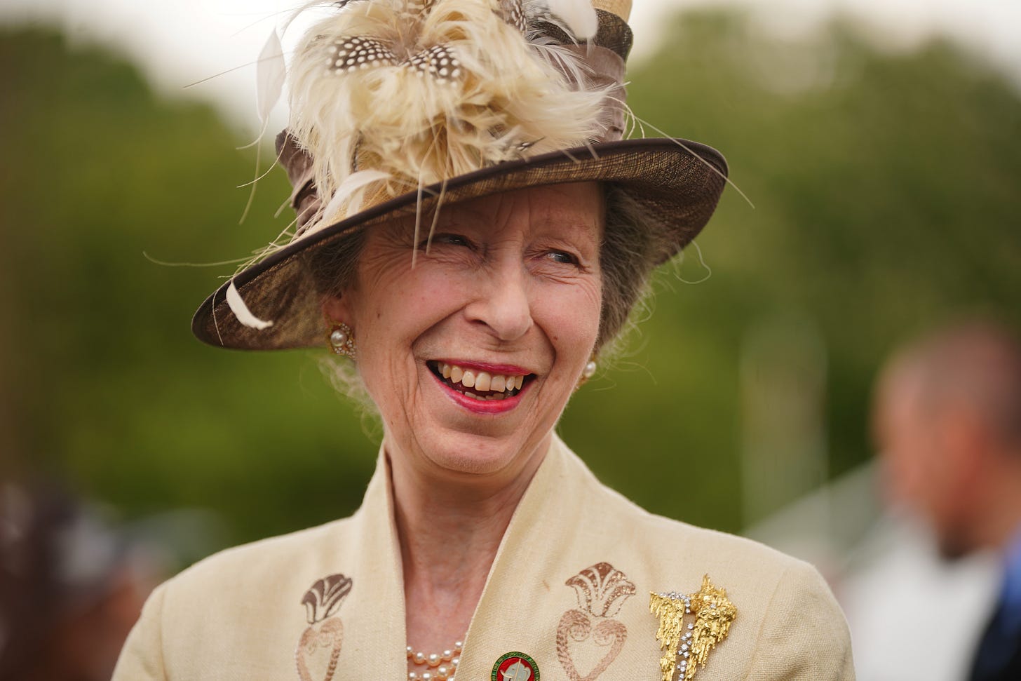 Princess Anne smiling and wearing a hat