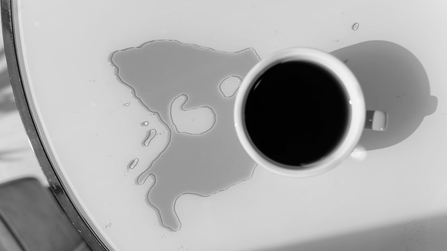 A spilled cup of coffee on a table, seen from above