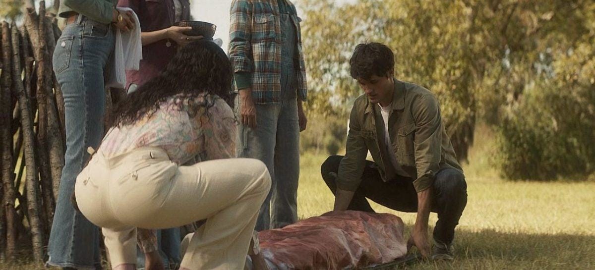 Gay Carlos is ultra tight pants helping John Winchester lift dead body on The Winchesters Art of Dying 1.06.