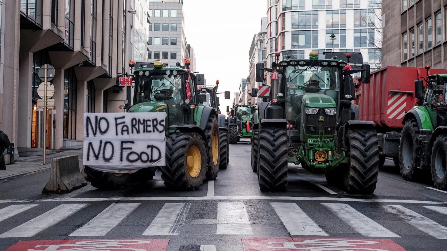 A farmer drives a tractor bearing a sign that reads “No Farmers, No Food,” during a farmers’ protest in Brussels