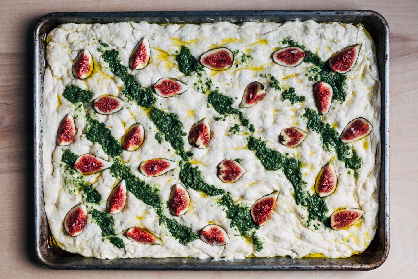 Focaccia dough with figs and pesto, ready for the oven.