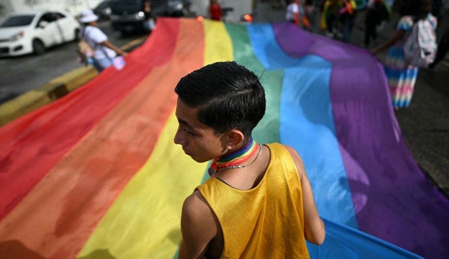 Supporters of the LGBTQ community hold a large rainbow flag as they take part in the Pride March in San Salvador on June 29, 2024. Photo by MARVIN RECINOS/AFP via Getty Images.